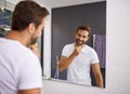 I do look good with a beard though. Cropped shot of a handsome man looking at himself in the mirror whilst touching his Royalty Free Stock Photo