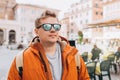 Cropped shot of a handsome man traveling through the city. Young men in sunglasses with a yellow backpack walking along Royalty Free Stock Photo