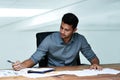 Working hard to meet the deadlines. Cropped shot of a handsome young businessman doing paperwork while working in a Royalty Free Stock Photo