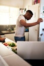 I feel like Im missing something.... Cropped shot of a handsome young man looking into his refrigerator while making Royalty Free Stock Photo