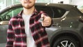 Cropped shot of a man holding out car keys to the camera posing at the dealership Royalty Free Stock Photo