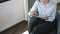 Happy businesswoman sitting on comfortable chair in office and using digital tablet. Royalty Free Stock Photo