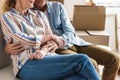 cropped shot of happy senior couple holding hands and sitting together on couch in new Royalty Free Stock Photo