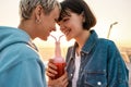 Cropped shot of happy young lesbian couple drinking from one glass bottle with the straw, Two women enjoying cold Royalty Free Stock Photo