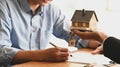 Cropped shot of House broker holding the sample house model in hand with his customer.