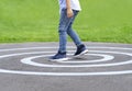 Cropped shot kid legs standing on circle line at asphalt, Active kid playing in the park