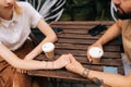 Cropped shot of loving young couple having coffee together and enjoying life sitting at table holding hands in street Royalty Free Stock Photo