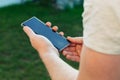 Close-up shot of male hands holding smartphone with blank screen copy space for your text message or information content, against