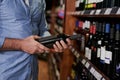 The store that stocks his favourite wine. Cropped shot of a man buying wine at a grocery store. Royalty Free Stock Photo