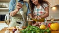 Cropped shot of man, chef cook using hand blender while preparing a meal. Young woman, girlfriend in apron pouring olive Royalty Free Stock Photo