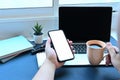 Man holding cup of hot coffee and using smart phone. Royalty Free Stock Photo