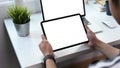 Cropped shot of man holding digital tablet with white screen and using computer laptop at home office room. Royalty Free Stock Photo