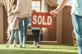 cropped shot of man holding sold signboard with young family moving into new Royalty Free Stock Photo