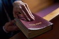 Finding comfort in the good book. Cropped shot of a man opening a bible while sitting in a pew at church. Royalty Free Stock Photo