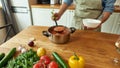 Cropped shot of man pouring tasty soup from pot into bowl. Italian cook preparing a meal in the kitchen. Cooking at home Royalty Free Stock Photo