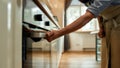 Cropped shot of man, professional cook opening electric oven, while preparing dinner at home. Hobby, lifestyle Royalty Free Stock Photo