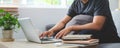 Cropped shot man sitting in living room and using laptop computer Royalty Free Stock Photo