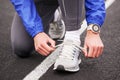 Cropped shot of a man tying his shoelaces on running shoes.