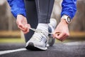 Cropped shot of a man tying his shoelaces on running shoes.