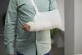 Man wearing a bandage and a sling after the surgery on his arm with a joint dislocation