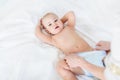 Cropped shot of mother changing diaper of adorable baby boy lying on bed Royalty Free Stock Photo