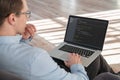 Cropped shot oof coder sitting with laptop on knees Royalty Free Stock Photo