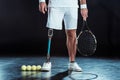 cropped shot of paralympic tennis player with racket in hand and tennis balls Royalty Free Stock Photo