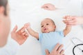 cropped shot of pediatricians tickling adorable little baby Royalty Free Stock Photo