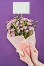 Cropped shot of person holding beautiful floral bouquet with blank card Royalty Free Stock Photo