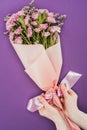 cropped shot of person holding beautiful floral bouquet with pink ribbon Royalty Free Stock Photo