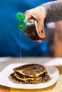Cropped shot of person pouring maple syrup onto stack of pancake Royalty Free Stock Photo