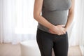 Cramps are normal during pregnancy. Cropped shot of a pregnant woman holding her stomach in pain while standing in her