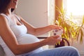 Pregnant woman holding joystick and playing video games