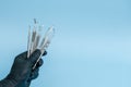 Cropped shot of professional dentist in black medical gloves with dental tools. Dental concept. Isolated on blue background Royalty Free Stock Photo