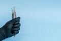 Cropped shot of professional dentist in black medical gloves with dental tools. Dental concept. Isolated on blue background Royalty Free Stock Photo