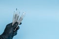 Cropped shot of professional dentist in black medical gloves with dental tools. Dental concept. Isolated on blue background Royalty Free Stock Photo