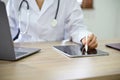 Cropped shot, Professional female doctor working at her office desk, using laptop and tablet Royalty Free Stock Photo