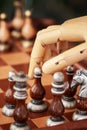 Cropped shot of robot hand playing chess, moving chess figure on chess board, selective focus