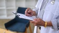 Senior doctor in white uniform working in medical office.