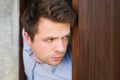 Cropped shot of senior man spying and entering through the door as concept of nosy man Royalty Free Stock Photo