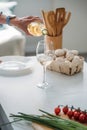 cropped shot of senior woman pouring wine into glass at counter with fresh vegetables in kitchen Royalty Free Stock Photo