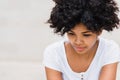Cropped shot of serious and sad black woman with Afro haircut wearing white t-shirt casual looking down posing over white