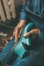 cropped shot of shoemaker holding boot workpiece and measuring sole outline