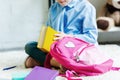 cropped shot of smiling child holding book while packing