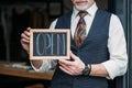 cropped shot of smiling mature tailor holding chalkboard with open sign Royalty Free Stock Photo