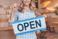 cropped shot of smiling waitress in apron holding sign open and smiling Royalty Free Stock Photo