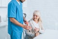 cropped shot of social worker giving glass of water and pills to senior woman Royalty Free Stock Photo