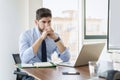 Shot of thinking businessman sitting behind his laptop while working at the office Royalty Free Stock Photo