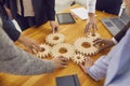 Company workers joining gear wheels as metaphor for effective teamwork and finding working solutions Royalty Free Stock Photo