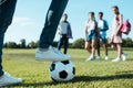 cropped shot of teenage classmates playing with soccer ball in park